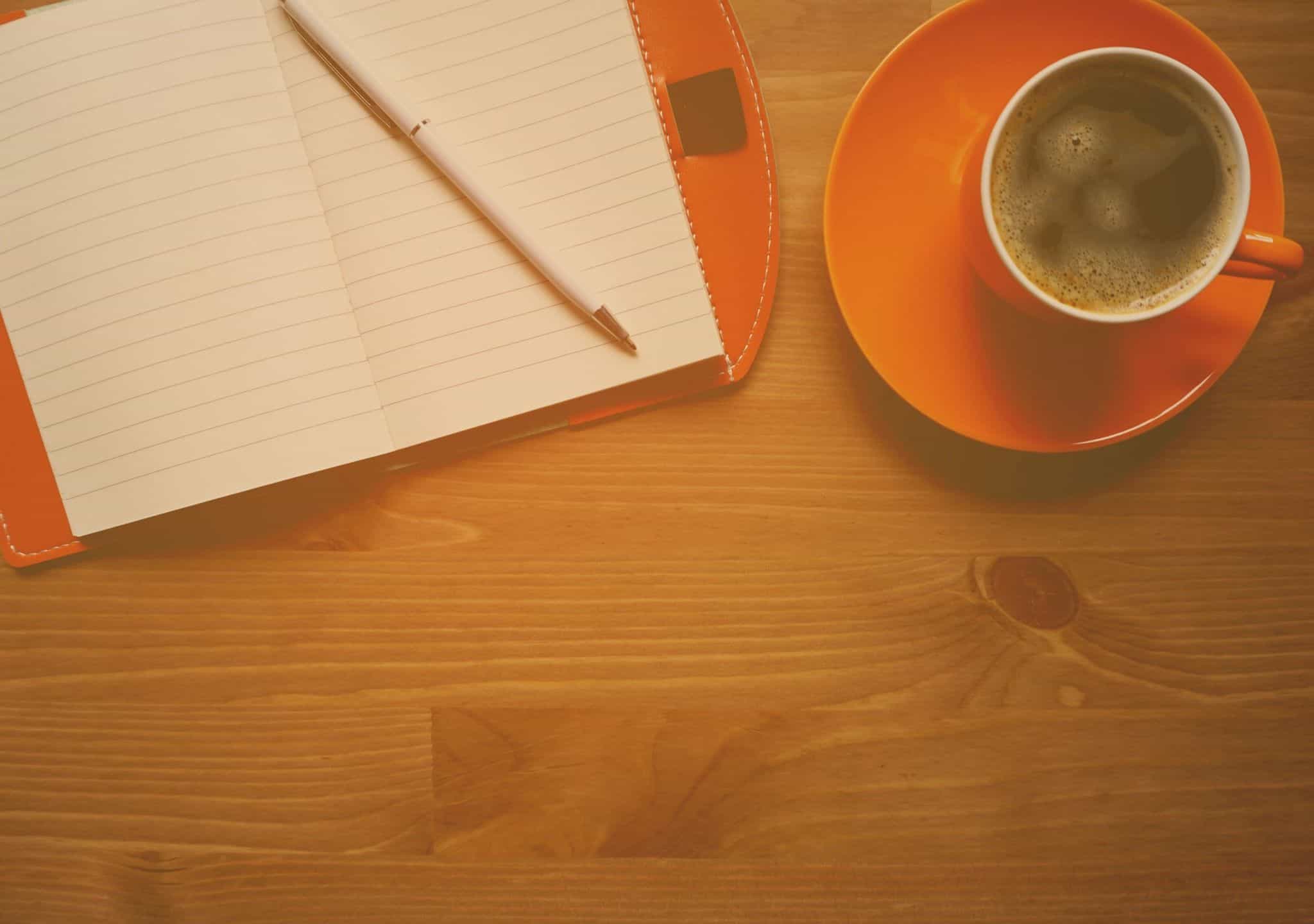 Coffee and a notebook on a writer's desk
